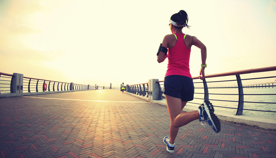 Runner athlete woman running at sunrise seaside. 