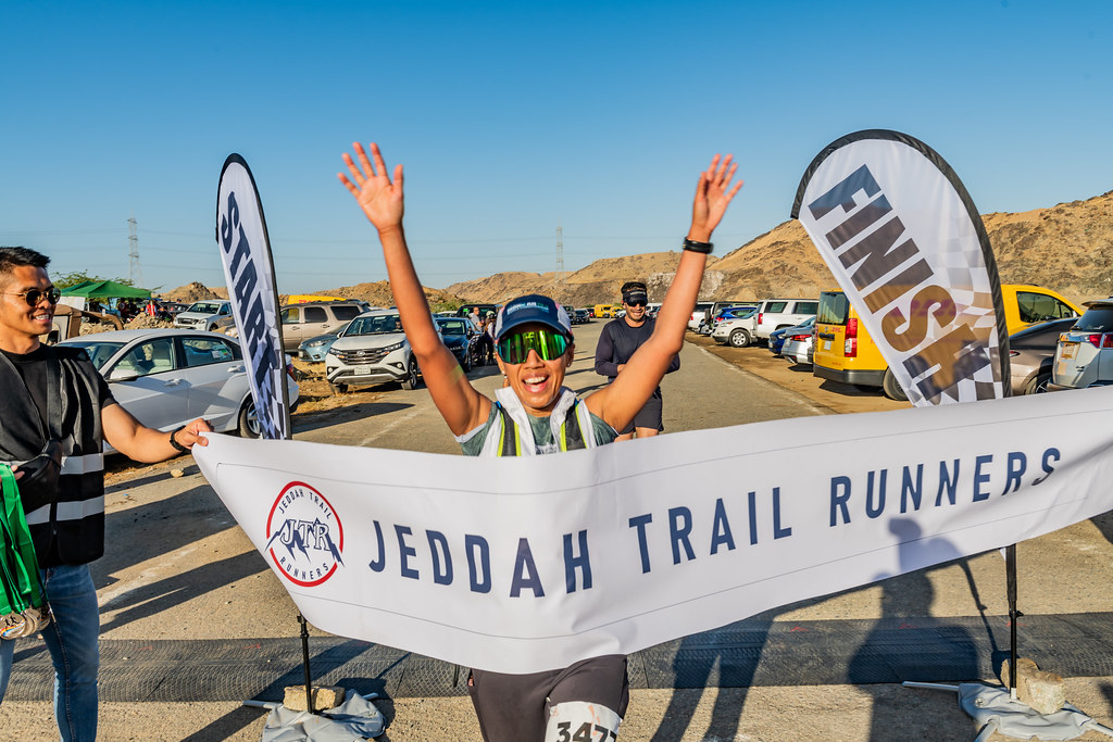 A woman reaching the finish line at the Jeddah Trail Runners