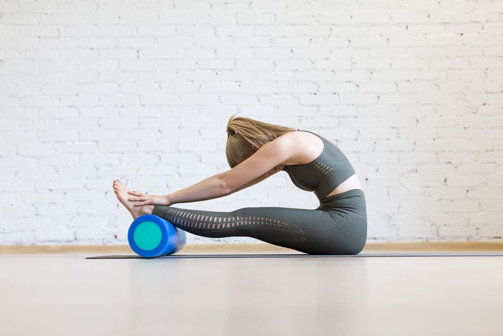 A woman foam rolling which is a way to help with the recovery process